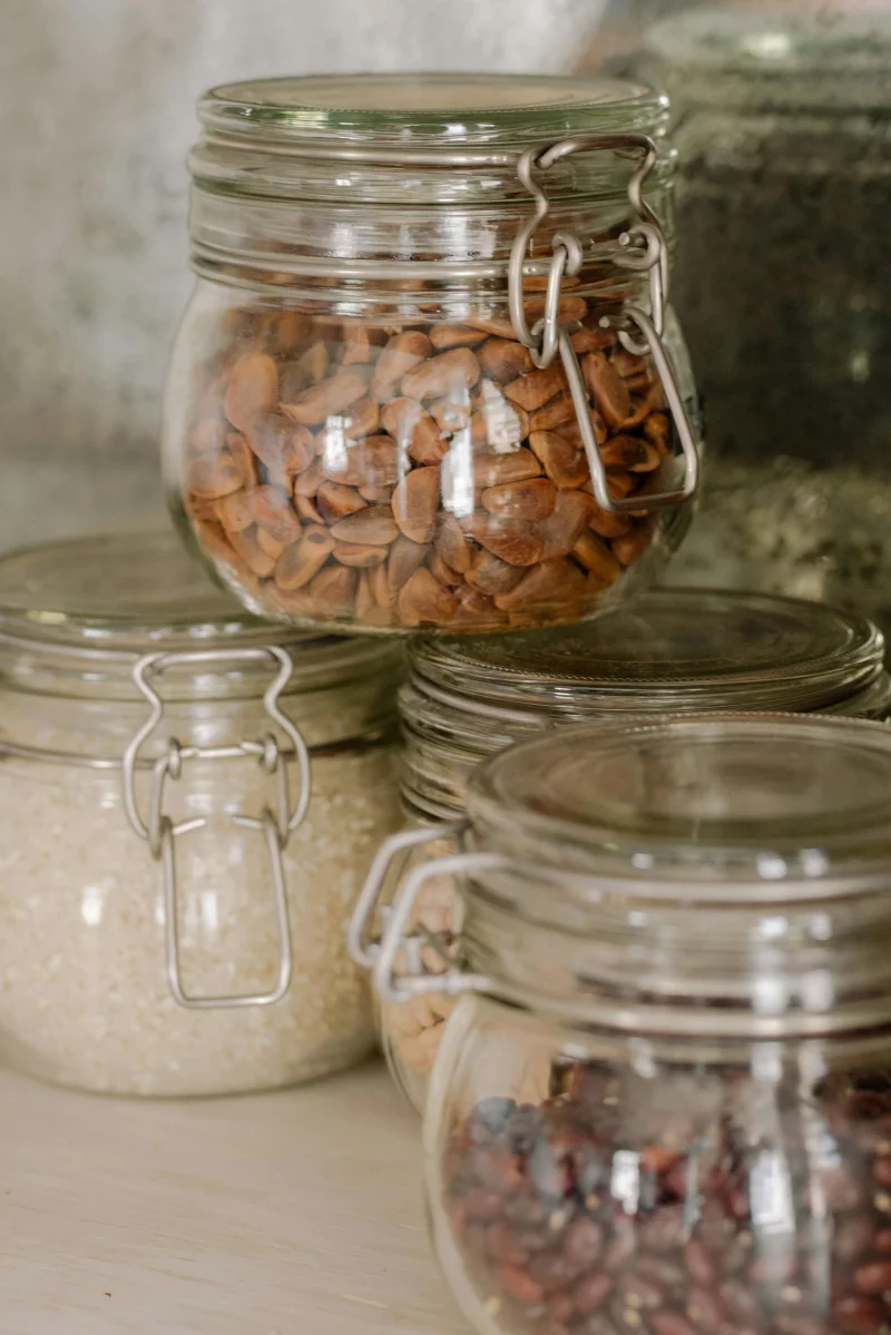 Stock photo of glass jars filled with nuts, rice, and beans in a kitchen setting.