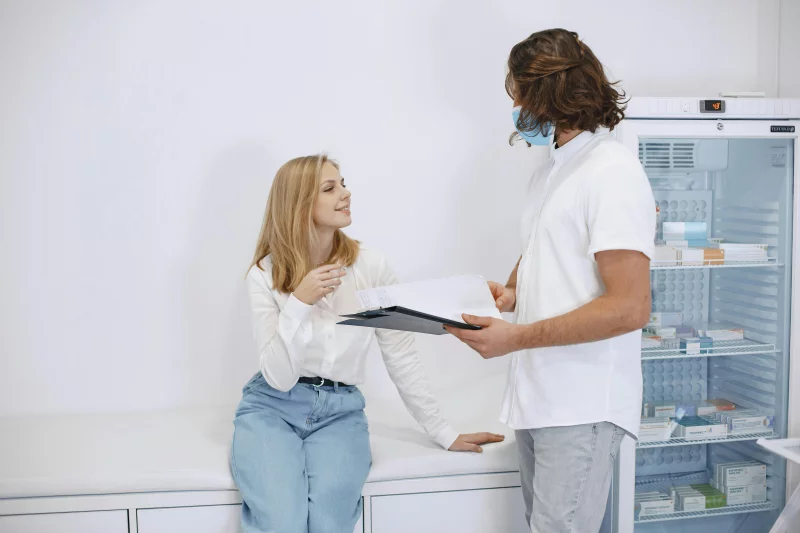 A healthcare professional consulting with a patient in a modern examination room.