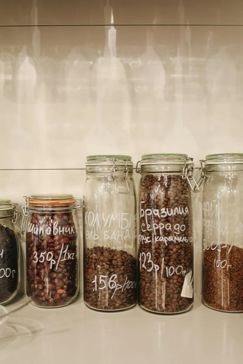 Neatly arranged glass jars filled with spices and coffee beans, promoting zero waste storage.