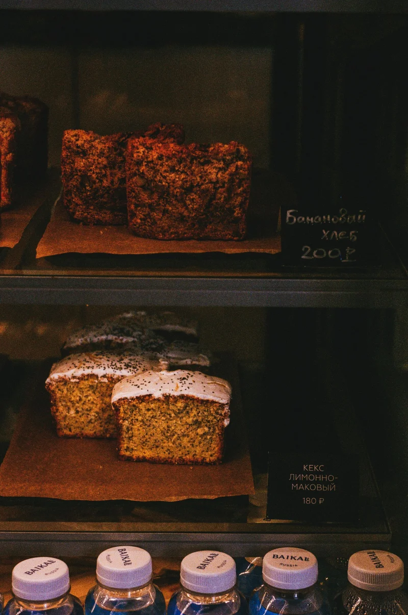 A cozy bakery display featuring rustic pastries on shelves with visible price tags.