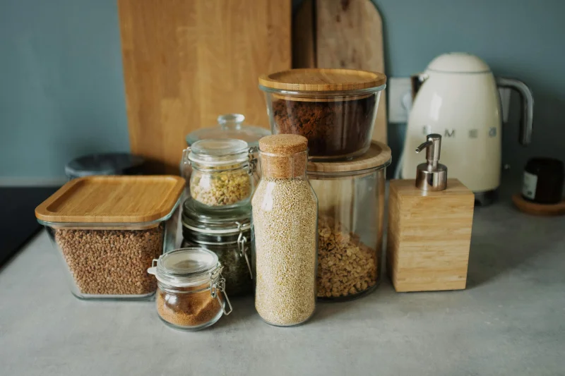 Stylish kitchen setup with glass jars, wooden accents, and a white electric kettle. Ideal for organization.