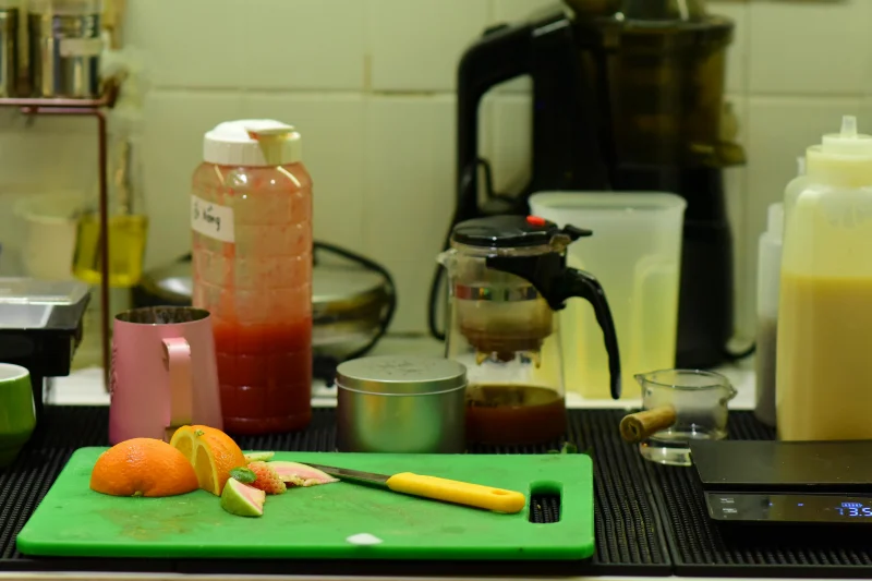 A kitchen counter with fresh citrus fruits, juice containers, and a juicer for home cooking inspiration.