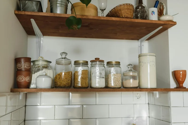Aesthetic kitchen shelves displaying various jars and containers for organized storage.