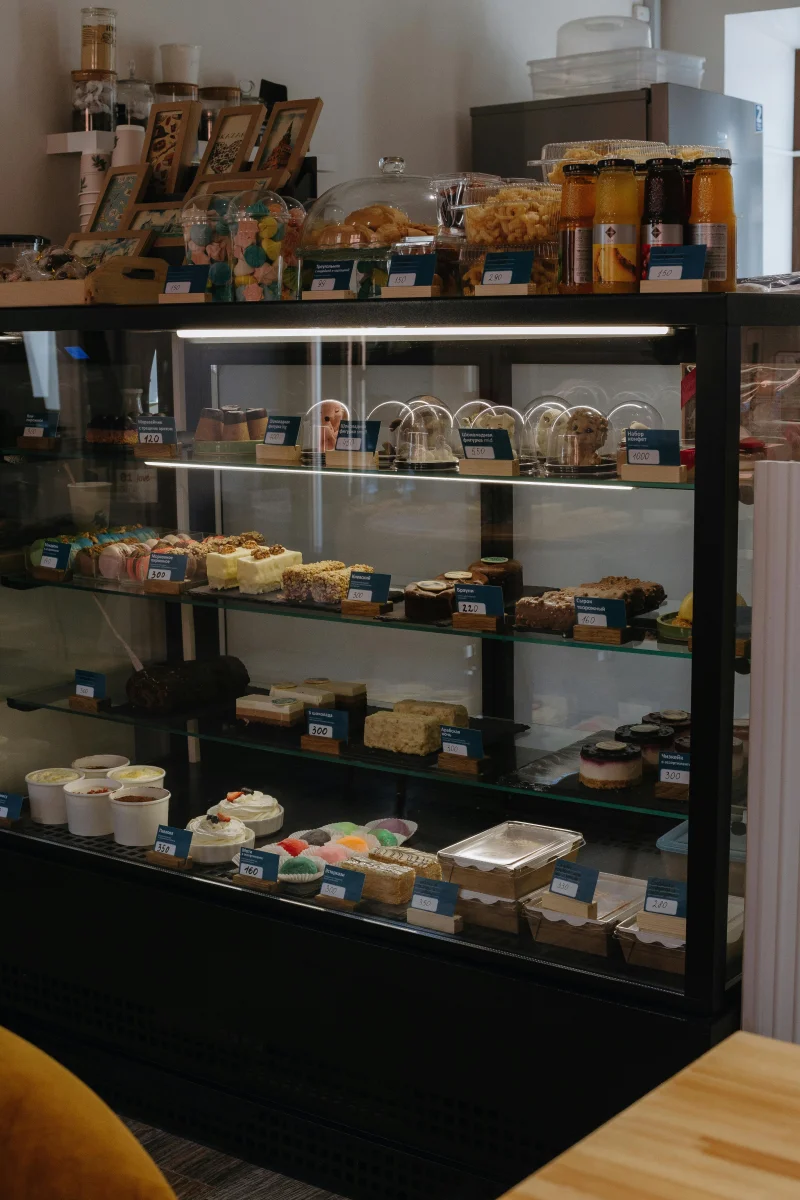 A tempting array of sweets and pastries beautifully arranged in a café display counter.