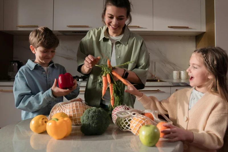 A family enjoys quality time in the kitchen, preparing a meal with fresh vegetables.