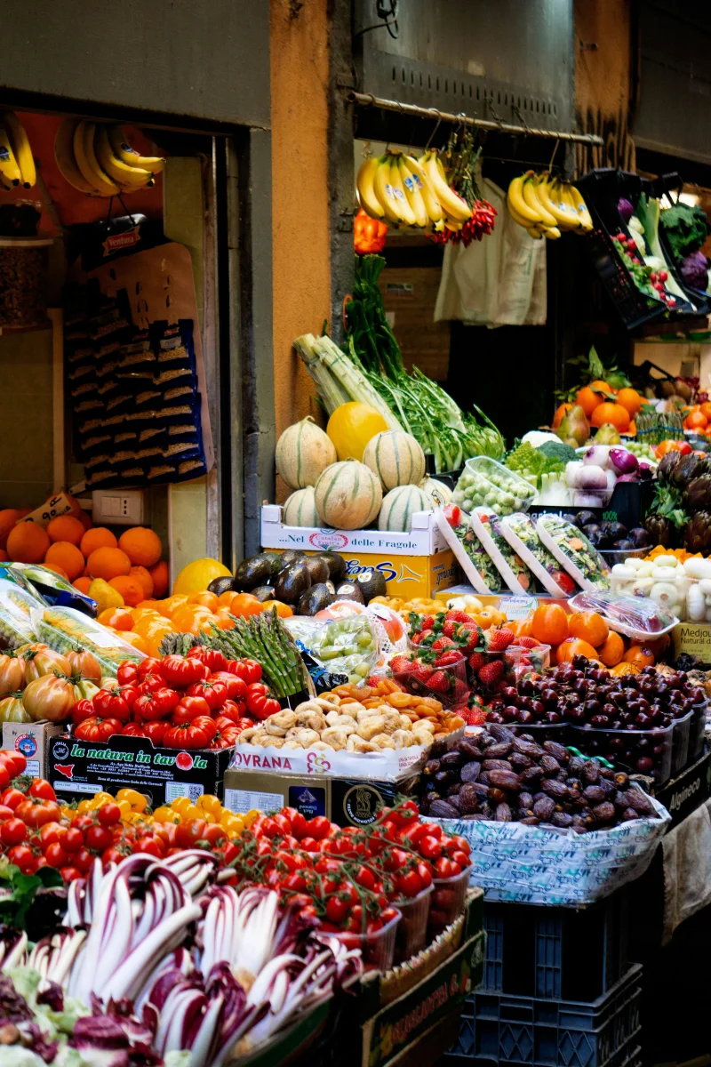 A colorful display of fruits and vegetables at an outdoor market stall.