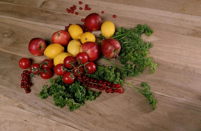 A vibrant assortment of fruits and vegetables on a wooden surface. Top view, bright and fresh.