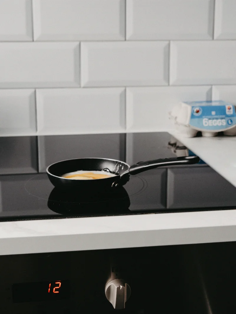 A modern kitchen featuring a frying pan on an electric stove, perfect for cooking enthusiasts.