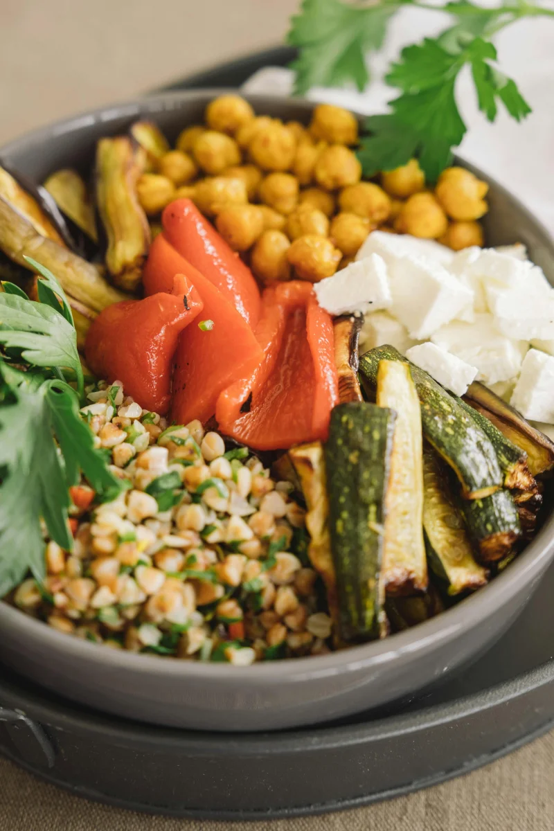 Delicious Mediterranean bowl featuring grilled vegetables, chickpeas, feta, and parsley.