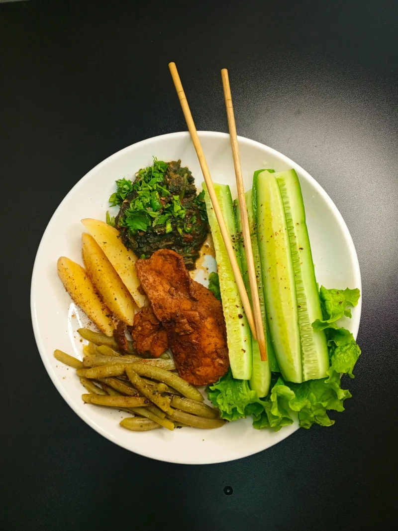 Delicious healthy plate featuring grilled chicken, fresh vegetables, and potato wedges.