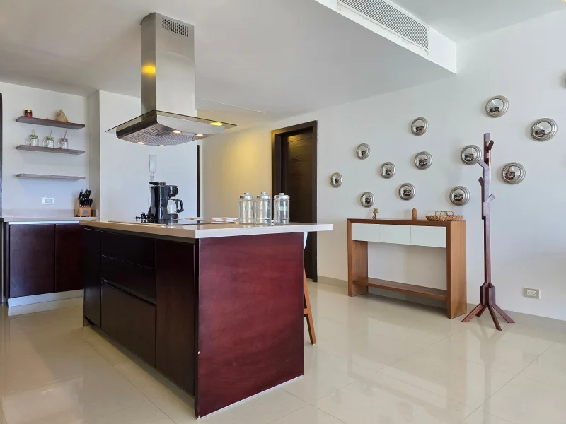 Sleek modern kitchen with central island, stainless steel decor, and wall-mounted art.