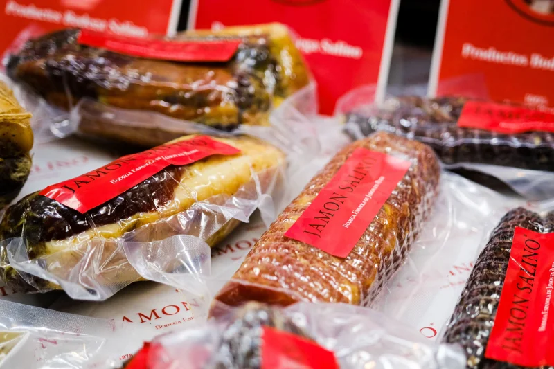 Close-up of assorted packaged Spanish cured meats with visible labels and textures.