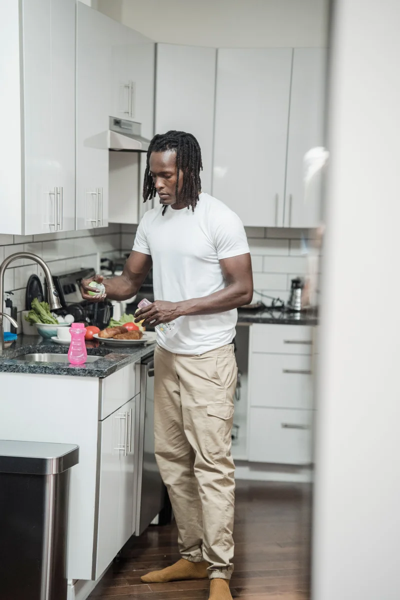Adult man cooking fresh food in a contemporary kitchen setting, highlighting home cooking and lifestyle.