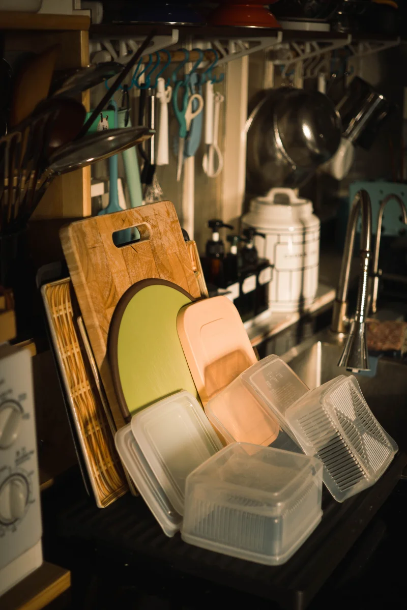 A well-organized kitchen sink area featuring cutting boards and storage containers in a cozy setting.