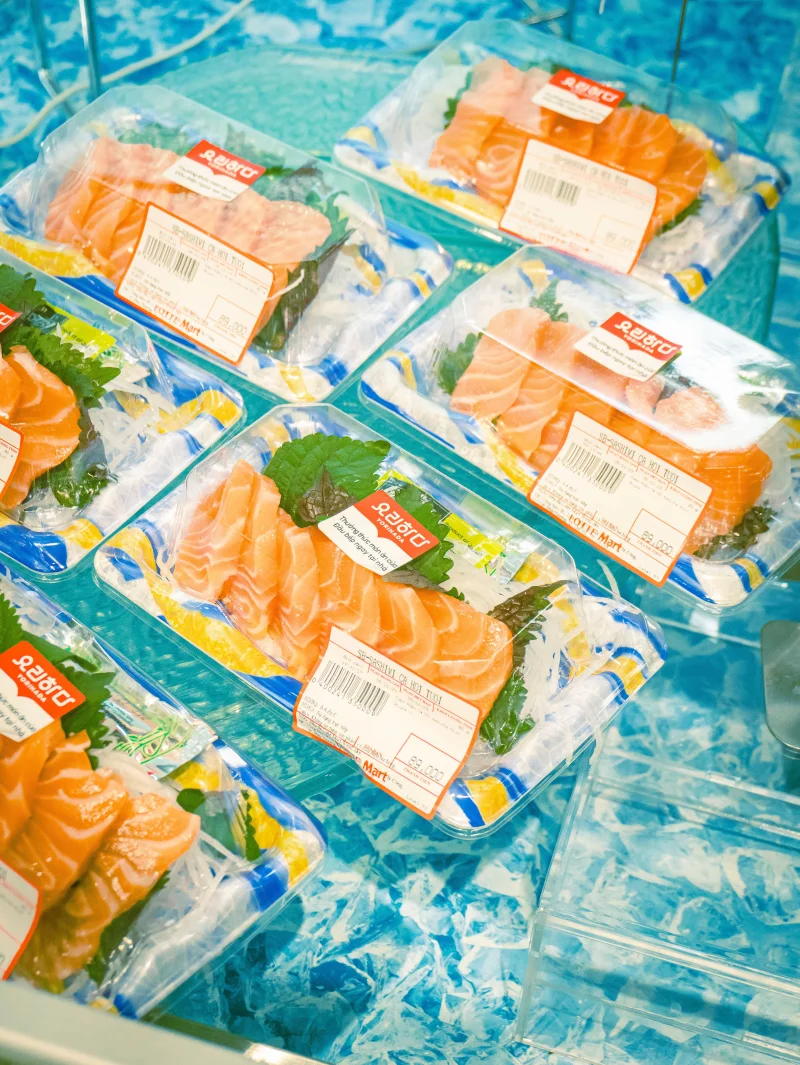 High-angle view of packaged salmon fillets in a refrigerated grocery store section.