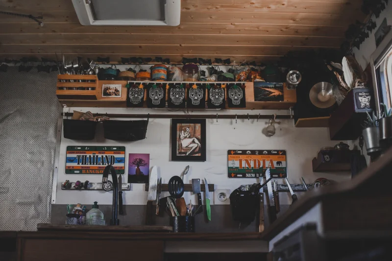 A cozy kitchen corner adorned with artistic elements, utensils, and decorative signs.