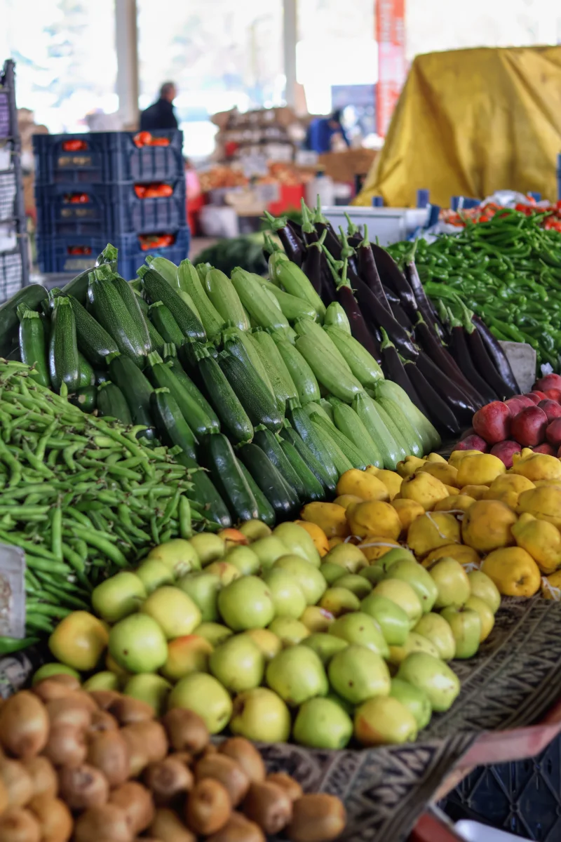 Vibrant display of fresh fruits and vegetables at an outdoor farmers market.
