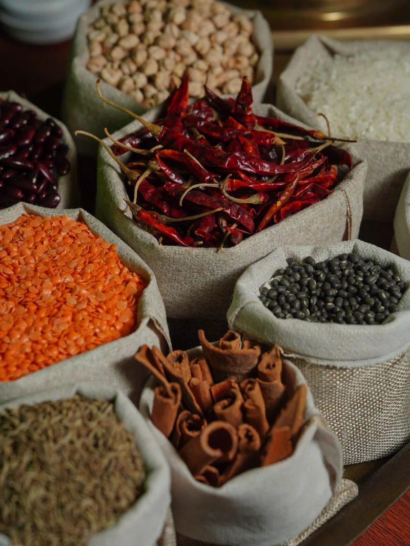 Assorted spices and grains in burlap bags, perfect for culinary exploration and food photography.