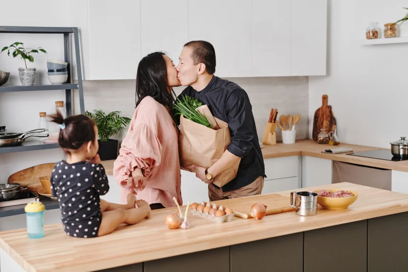 A family shares a loving moment while preparing a meal in their modern kitchen.