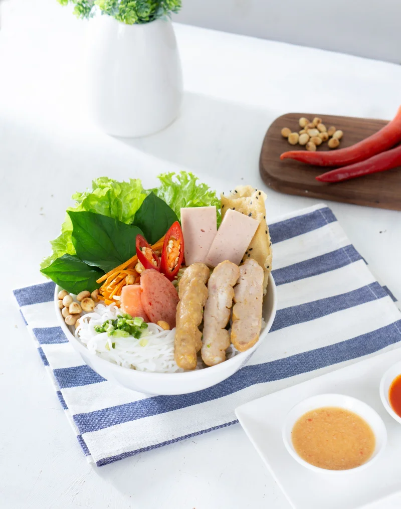 Healthy Vietnamese noodle bowl with fresh vegetables and sauces, perfect for lunch or dinner.
