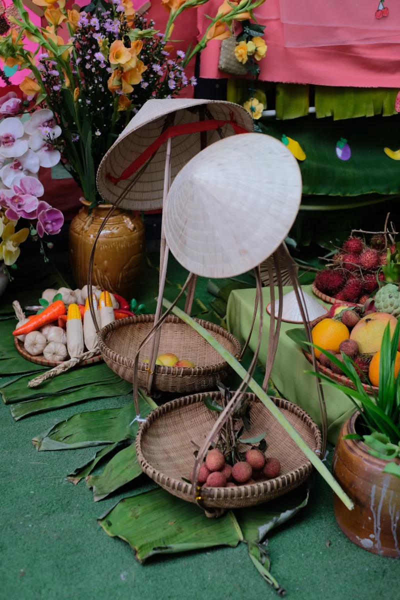 Vibrant market scene featuring tropical fruits and vegetables with traditional conical hats.