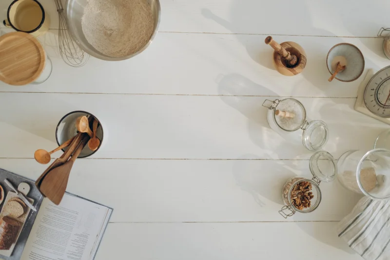 Flat lay of rustic baking ingredients and tools on a wooden countertop, perfect for culinary inspiration.
